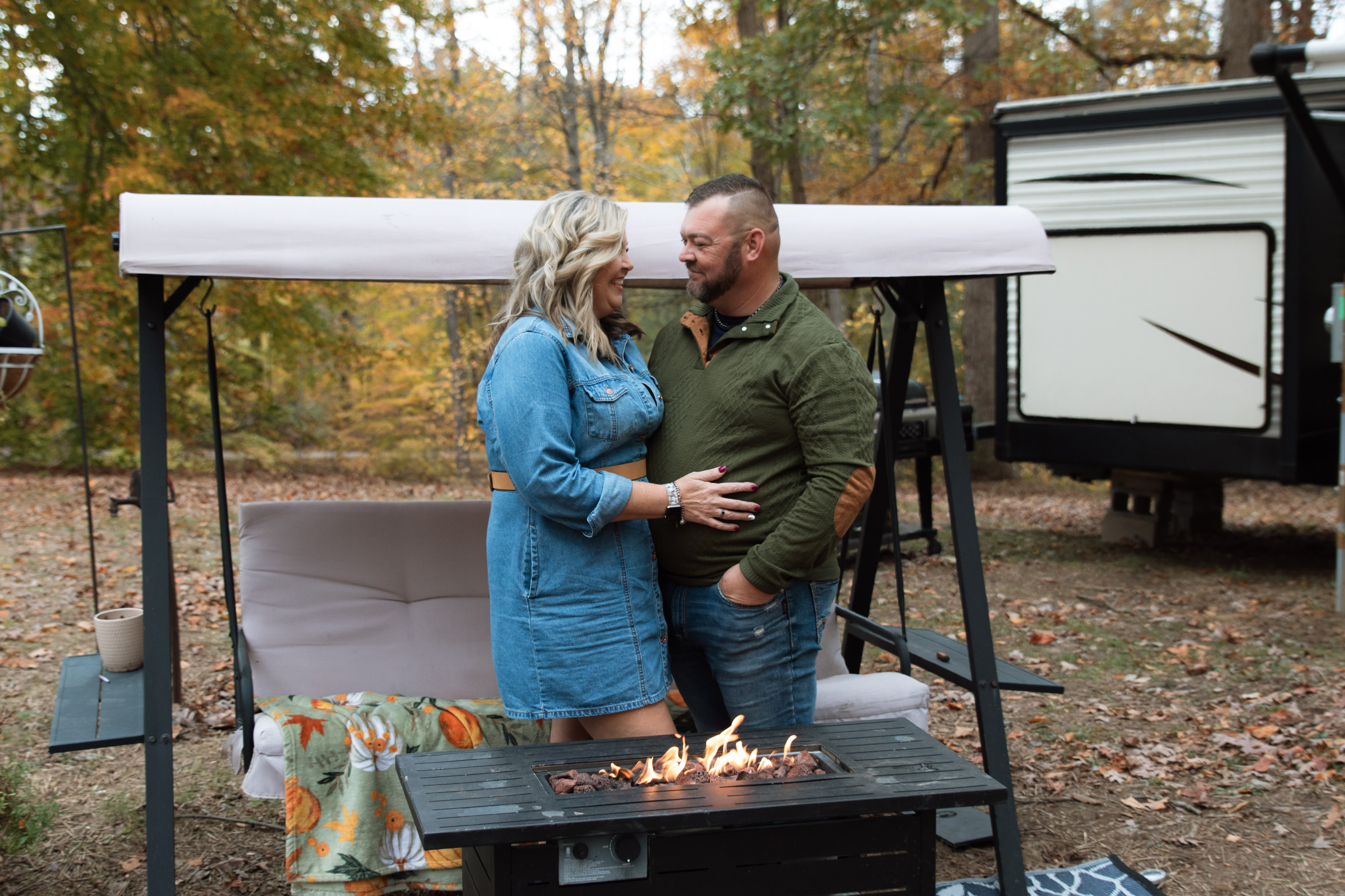 Couple on their camper porch during lifestyle photography session with dogs and woods in background